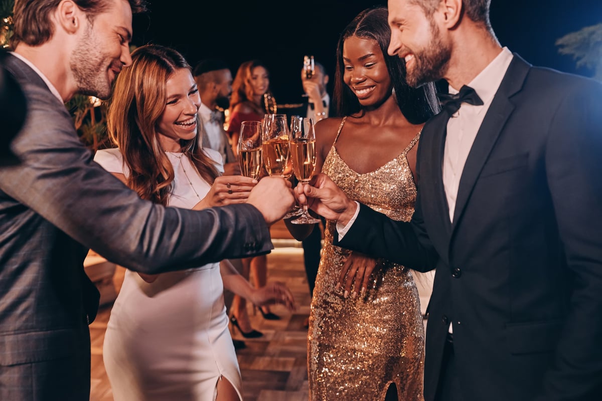 Group of people in formalwear toasting with champagne at luxury party