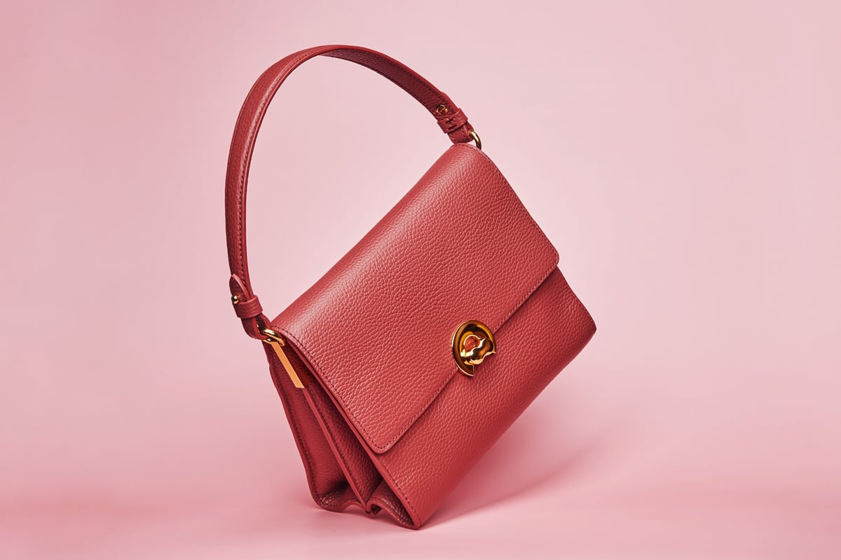 Luxury red brown leather handbag isolated on pink background fashion accessory