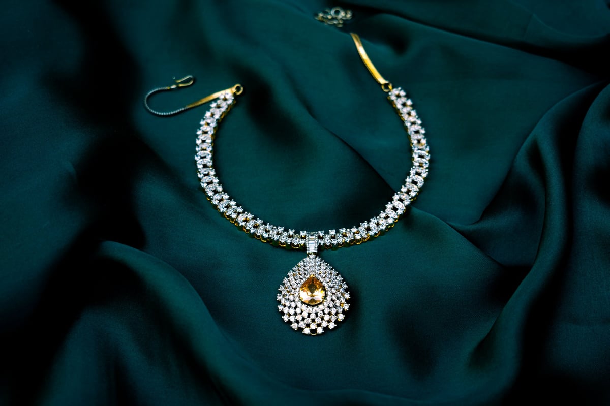 Luxurious white gemstone necklace on green velvet surface high resolution