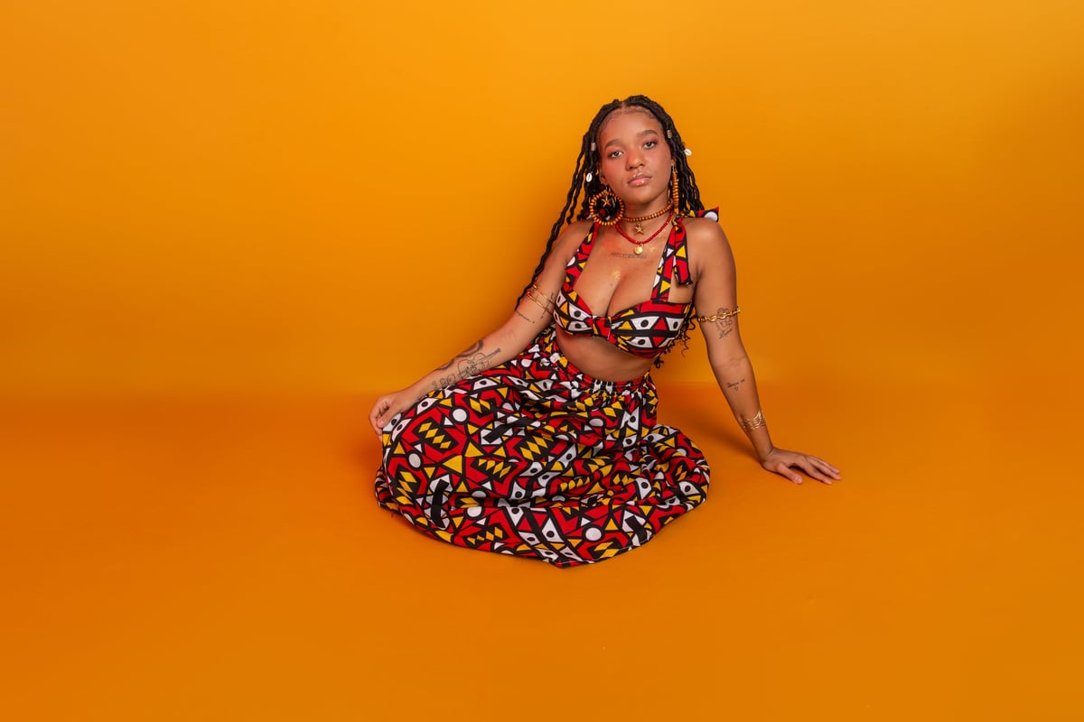 Beautiful woman with braids wearing traditional clothing posing confidently