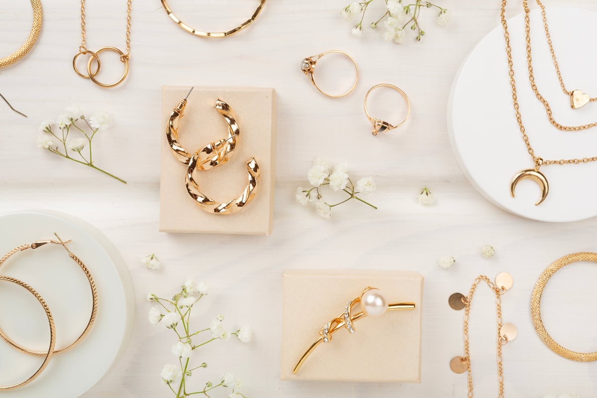 Elegant golden jewelry with decoration on wooden background top view