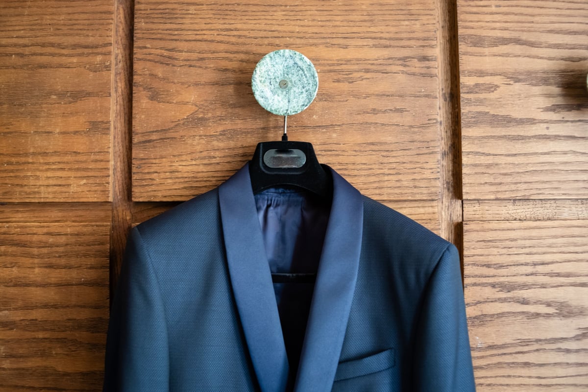 Tailored blue suit displayed on hanger ready for wedding day