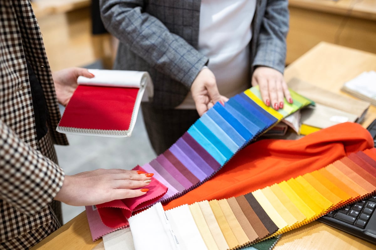 Two people collaborating over colorful fabric swatches for fashion design