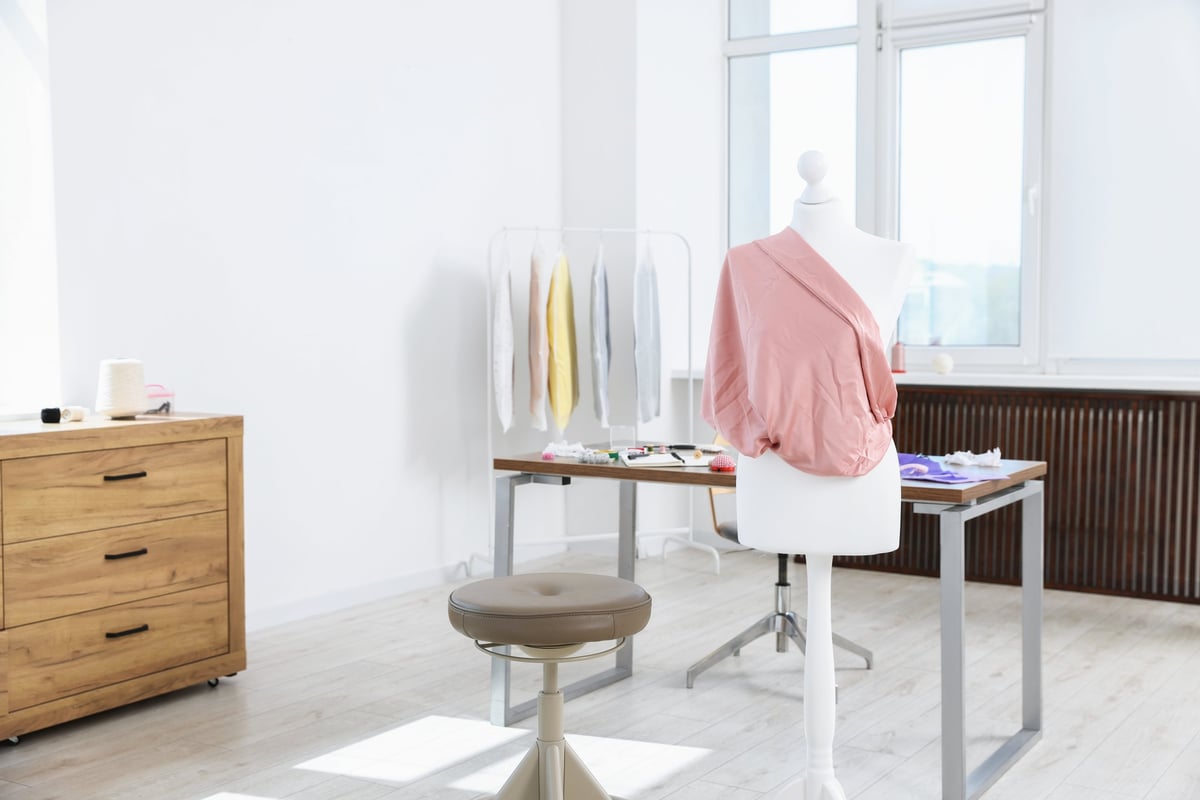 Female mannequin with fabric and sewing supplies in atelier