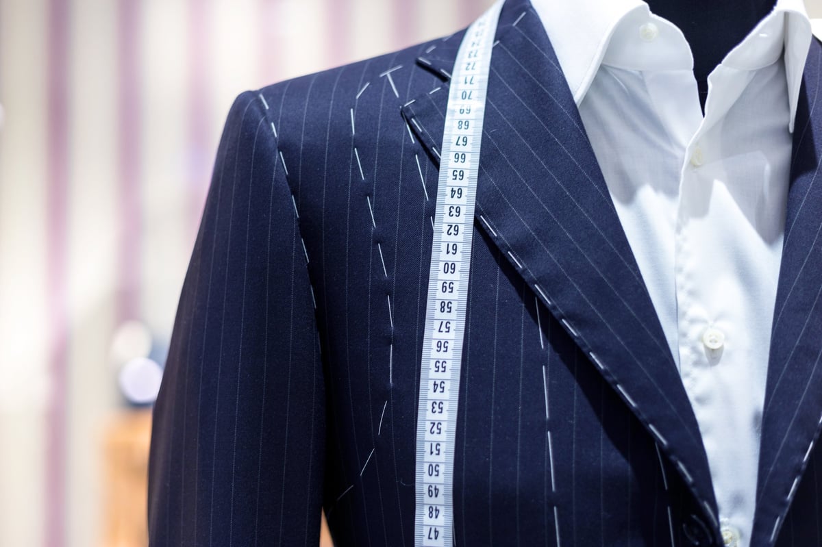 Luxury tailored suits displayed on mannequins in an elegant boutique