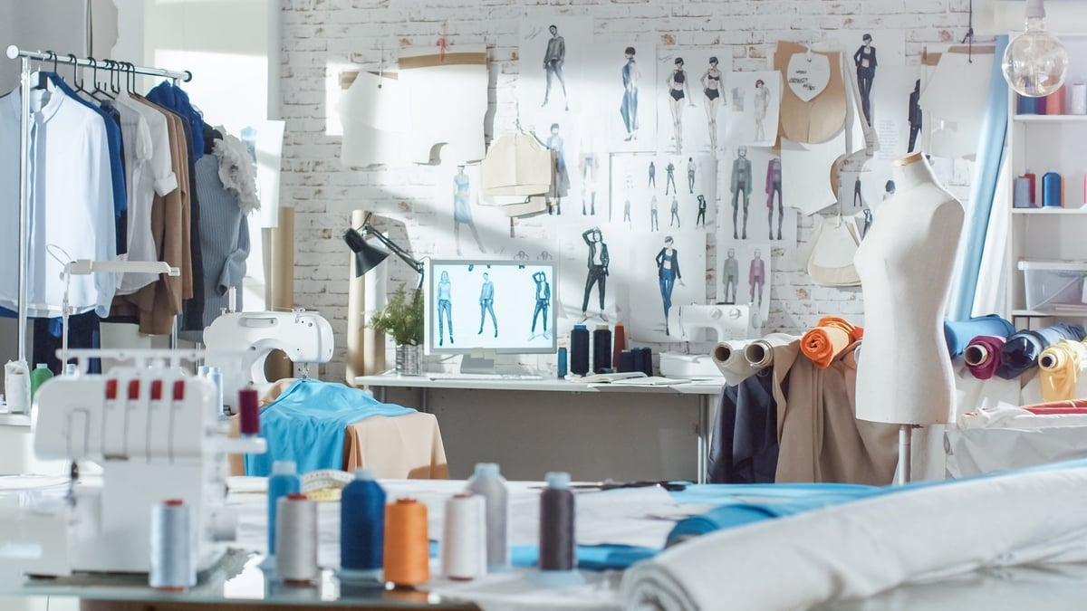 Shot of a Sunny Fashion Design Studio with sewing machine, hanging clothes, mannequins and colorful fabrics